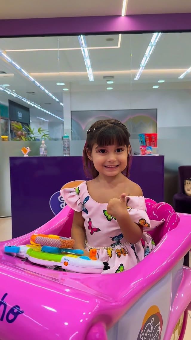 Criança sorrindo em cadeira lúdica do salão Meu Cabelinho